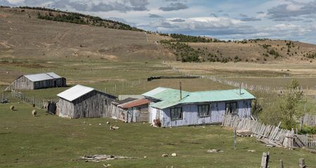 Puerto Natales, Chile - November 08 2016: A farm with constructions made by sheets and wood in the...