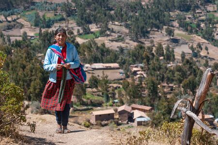 Pisac, Peru - August 8 2011: A local girl walking and her town.のeditorial素材