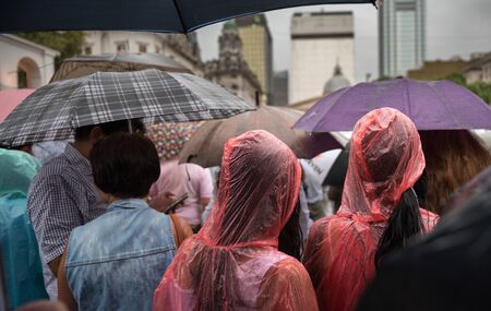 People in the streets of the city under the rain
