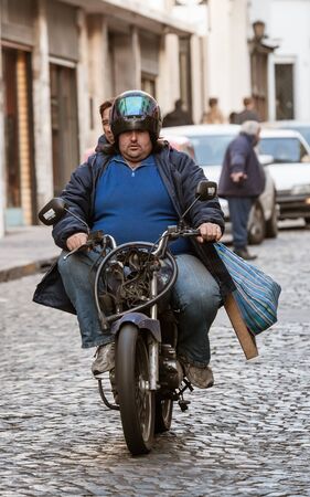 Buenos Aires, Argentina - Julio 02 2011: Streets of San Telmo a neighborhood of Buenos Aires city. A motorcycle that should not have a circulation permit, the driver and companion without thr proper helmet.のeditorial素材