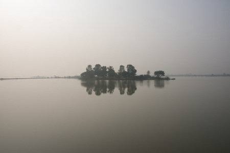 Reflection of wooded island in lakeの写真素材