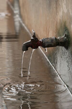 Dripping tap in streetの写真素材