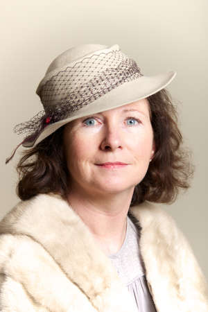 Brunette smiling in beige hat and furの写真素材