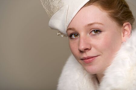 Redhead smiling in white feathered hat and furの写真素材
