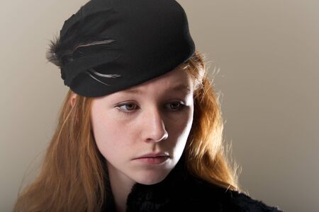 Close-up of redhead in black feathered hatの写真素材