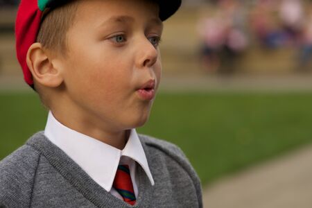 Close-up of uniformed schoolboy blowing out cheeksの写真素材