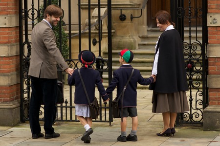 Family of four entering old school gatesの写真素材