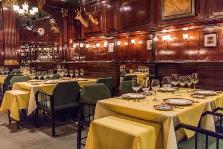 Tables laid for guests at wood-panelled restaurantのeditorial素材