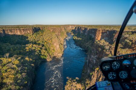 Aerial view of sunlit canyon from helicopterの写真素材