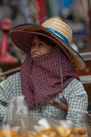 Woman in hat laughs in floating marketのeditorial素材