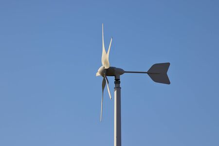 Wind generator on blue sky background. Wind electricity, renewable energy, wind farm, power plant.