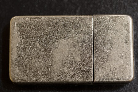 Gasoline lighter at dark wooden table. Silver lighter. Smokers gadget.の写真素材