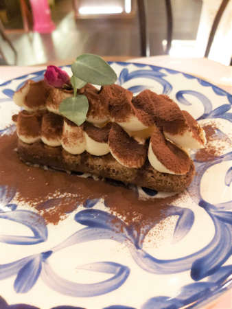 Tiramisu cheesecake on a blue plateの写真素材