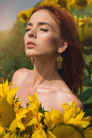 young beautiful girl in the field with flowersの写真素材