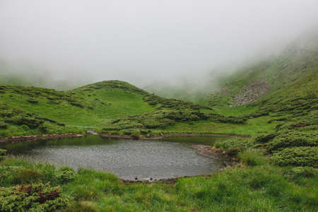 Beautiful mountains in Carpathian.Wild nature.Wonderful lake against the background of fogの写真素材