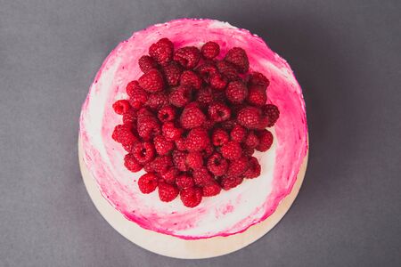 A delicious cake decorated with raspberries on a gray background.の写真素材