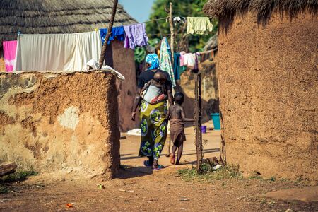 An African woman carries her child on her back in Ghana