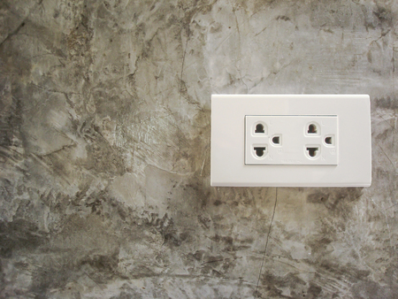 White plug socket on the Cement wall