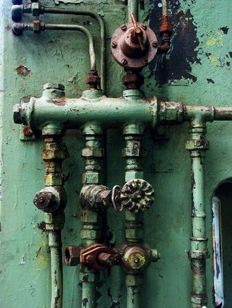 Old rusty pipes and valves with water leaks