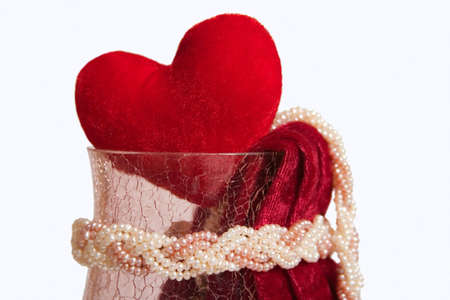 red velvet heart in teh crystal vase with piece of red velvet and pearl beads. Isolated on white background.の写真素材