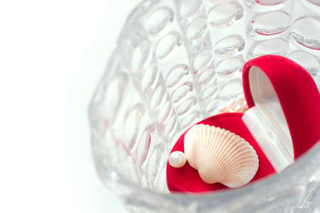 red box with white pearl and shell in a crystal vase. Focal point is on the pearl. Copy space is on the left side of imageの写真素材