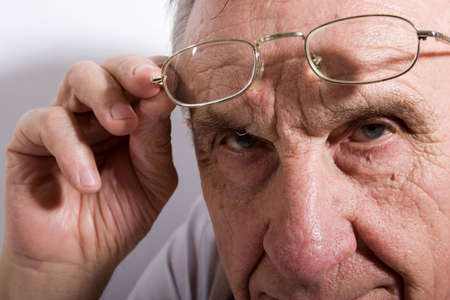 Portrait of concentrated serious old man in glasses. Close-up.の写真素材