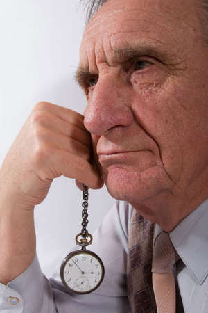 portret of serious old man with watch in his handの写真素材
