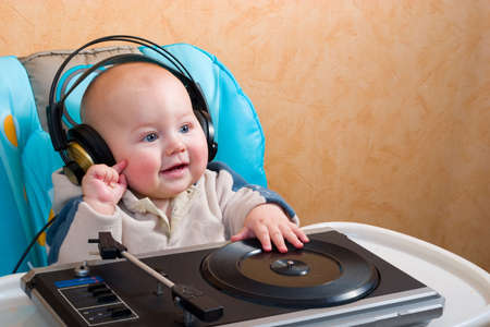 baby with headphones playing with turntableの写真素材