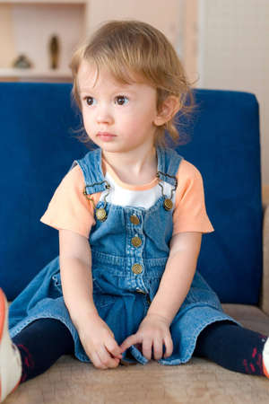 little cute girl sitting on the sofa.の写真素材