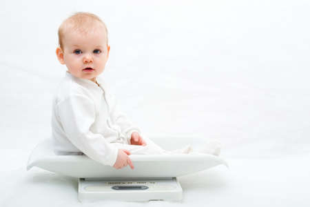 baby on scales on white background, with copy spaceの写真素材