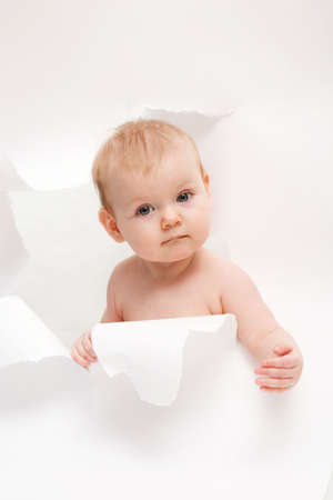 little cute baby breaking through white paperの写真素材
