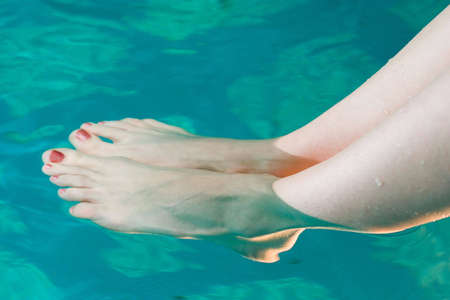 beautiful woman feet relaxing in the clear waterの写真素材
