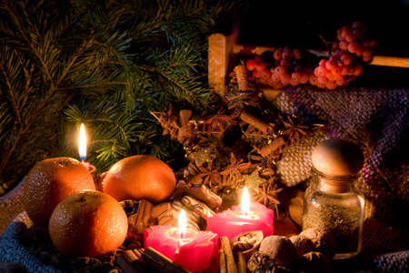Christmas still-life - candles, mandarines, cookies, cones, nuts and spices. Low DOF, copy space on top.の写真素材