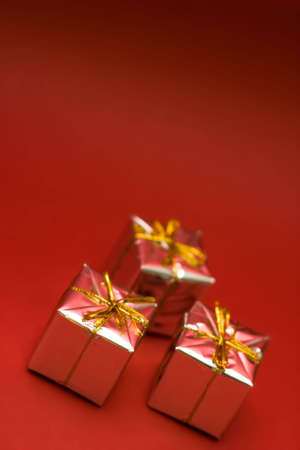 Little boxes with gifts on red background. Low DOF, copy space on top