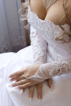 Beautiful bridal decollete - dress, gloves and necklace, and perfect manicure. Focus is on breastの写真素材