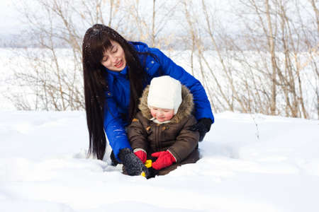 Mother and child playing with snowの写真素材