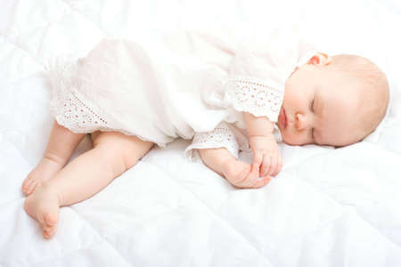 cute little baby sleeping on white blanketの写真素材