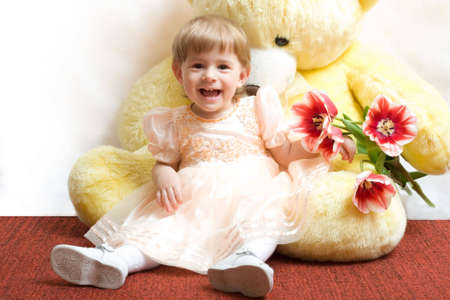 Cute little girl with tulips and teddy bearの写真素材