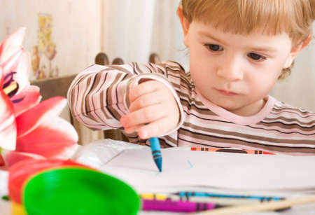 Little girl drawing with colorful crayonsの写真素材