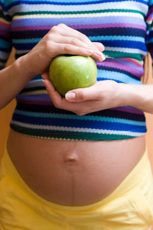 colorful image of pregnant body. Focus on handsの写真素材