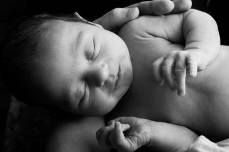 Newborn child in the hands of mother
