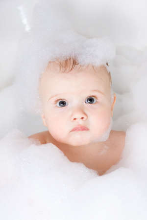 Cute baby having bath in the foamの写真素材