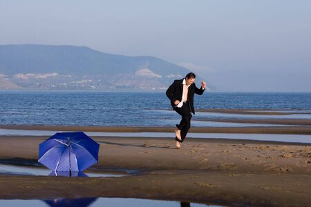 Happy businessman dancing on the beach - freedom conceptの写真素材