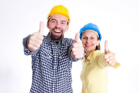 two young people wearing hardhats smiling to cameraの写真素材