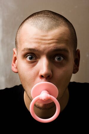 immaturity concept - adult man with dummy in the mouthの写真素材
