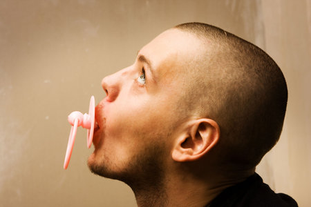 immaturity concept - adult man with dummy in the mouthの写真素材