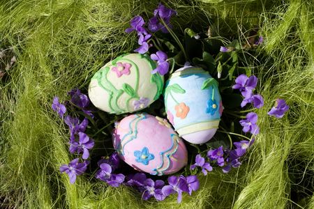 Three colored easter eggs in the green grass