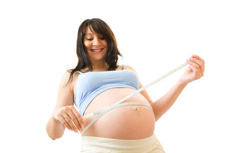 Pregnant woman measuring her stomach. Isolated over white