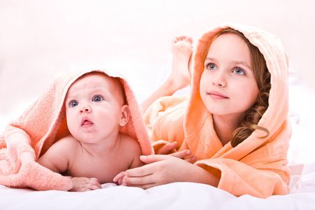 Two sisters with towels isolated on white backgroundの写真素材
