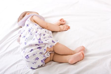 Happy little cute girl sleeping on the bedの写真素材